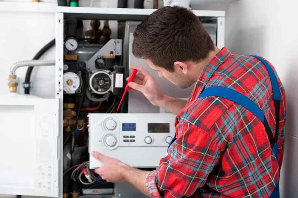 Technician Installing Water Heater System — Plumber in Armidale NSW