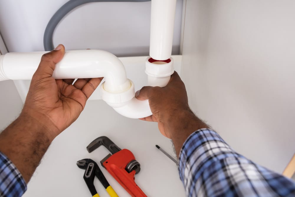 Plumber Fixing A Kitchen Sink Pipe